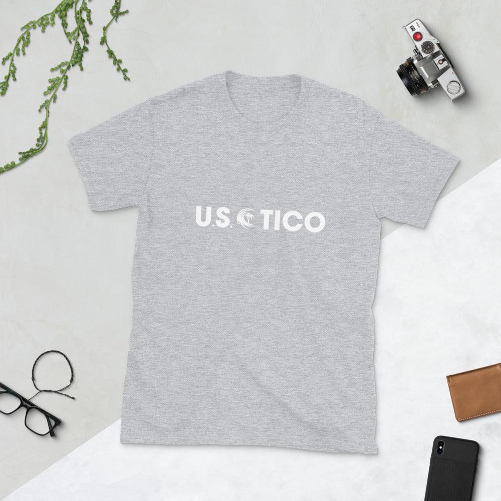 Grey t-shirt with white 'U.S. TICO' logo, styled with a camera and glasses on a light background.