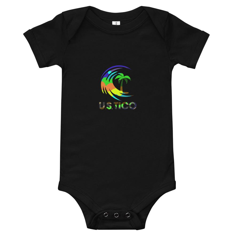 US Tico Baby Short Sleeve One Piece in black cotton with a colorful tropical palm tree and wave logo print